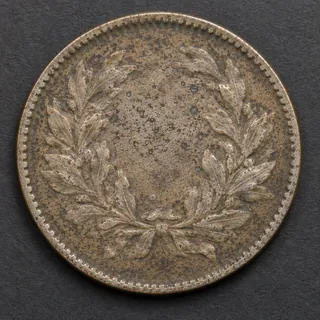 Sharp reverse view of a worn coin with a wreath design.