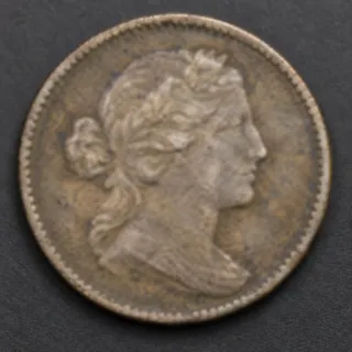 Soft focus blurs the coin portrait and its rim detail.